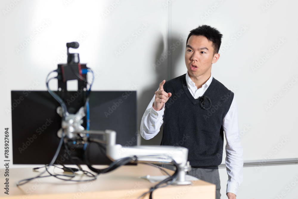 Fototapeta premium Young tutor teaching in front of the camera for an online class