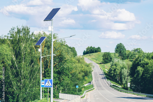 Solar device with street lamp on background of blue sky. Street light powered by solar panel with battery included. Alternative energy from the sun