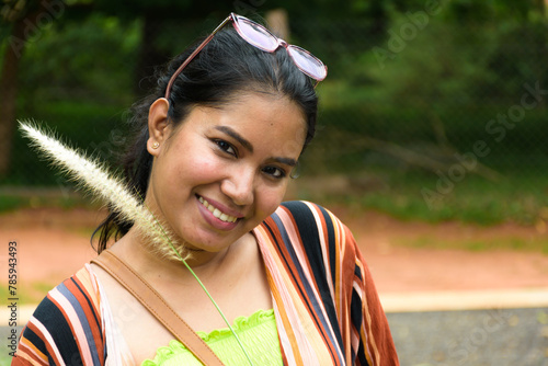 Beautiful young Indian woman behind grass in the grass field Giving the feeling of relaxation, relaxation and freedom