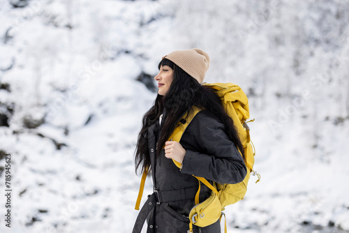 Adventurous Woman with Yellow Backpack Hiking in Snow