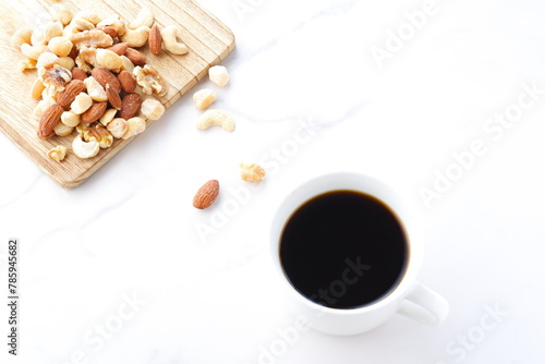 栄養たっぷりのミックスナッツ（アーモンド、クルミ、カシューナッツ、マカダミアナッツ）とコーヒー 