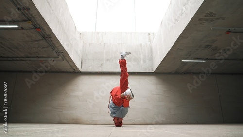Happy dancing man enjoy practice break dance or freestyle dance in building. Professional b-boy dancer perform energetic movement or doing freeze pose modern life style. Outdoor sport 2024. Sprightly.