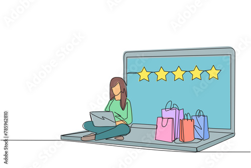 Single continuous line drawing happy woman sitting on giant laptop typing on laptop computer. Bought a lot from online shop. Give a rating of 5 stars. Ecommerce. One line design vector illustration