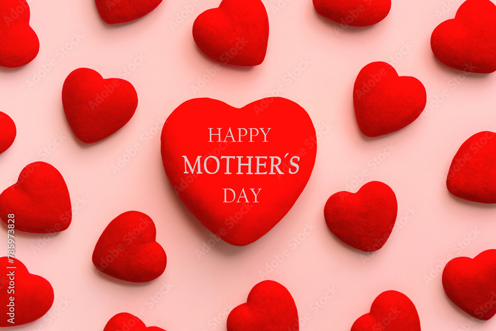 Happy Mother's Day. Top view of red heart with the text Happy Mothers day and many little red hearts