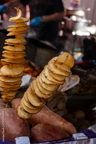Fried sweet potatoes chips, spirals on skewers on Portobello road food market, London, UK