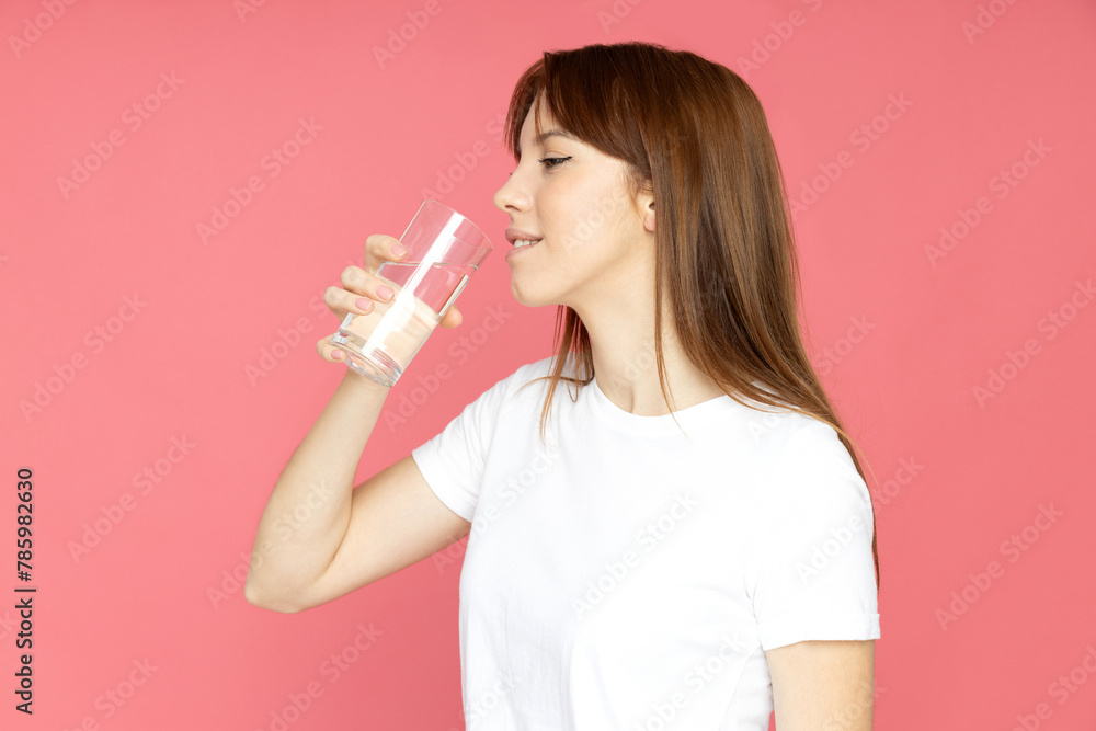 An attractive young girl with a glass of water in her hands An attractive young girl with a glass of water in her hands