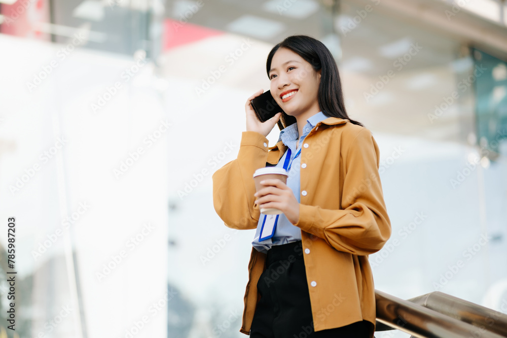 Fototapeta premium Young Asian business woman leader entrepreneur, professional manager holding digital tablet computer uon the street in big city
