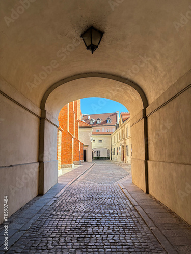 Narrow sunny street between colorful buildings of old town  City street of old town in Warsaw.