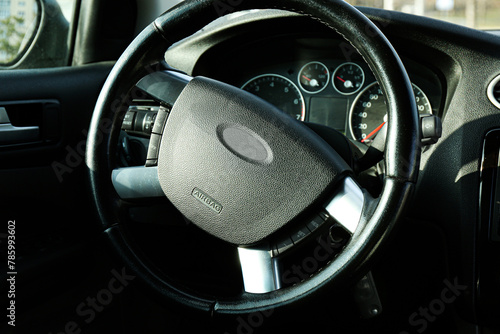 Black steering wheel and dashboard in car © New Africa