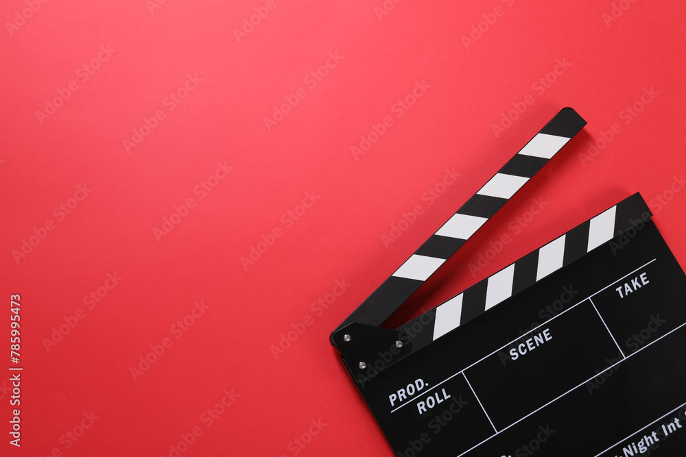Clapperboard on red background, top view. Space for text