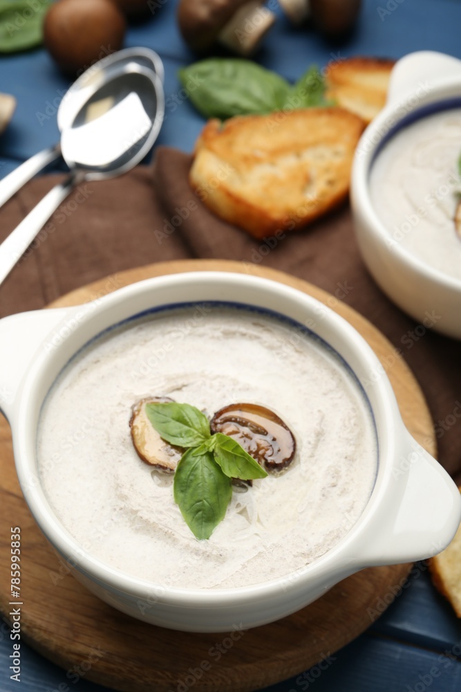 Fresh homemade mushroom soup served on blue wooden table Fresh homemade mushroom soup served on blue wooden table