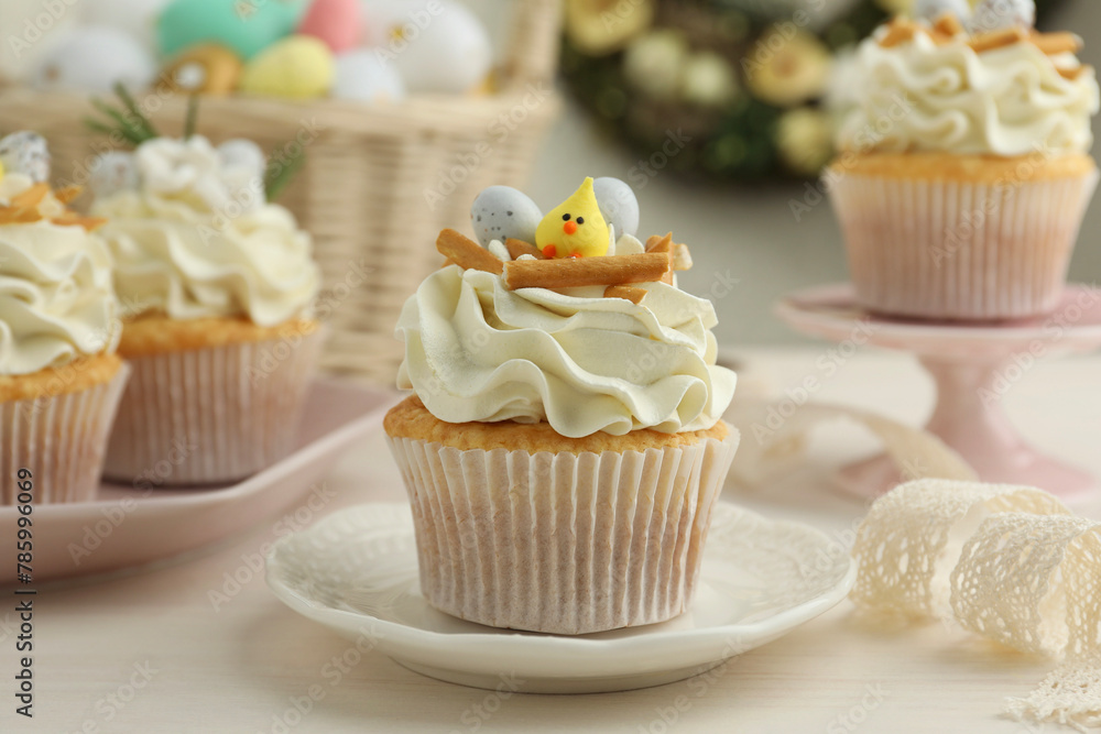 Tasty Easter cupcakes with vanilla cream on light wooden table