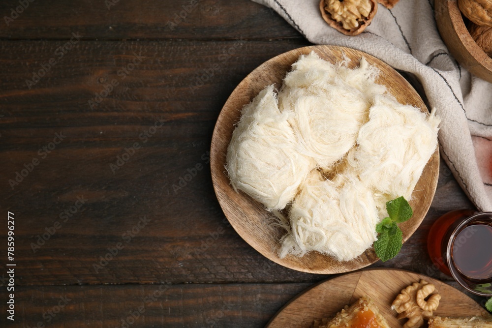 Eastern sweets. Tasty Iranian pashmak and tea on wooden table, flat lay. Space for text Eastern sweets. Tasty Iranian pashmak and tea on wooden table, flat lay. Space for text