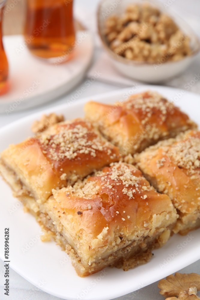 Eastern sweets. Pieces of tasty baklava and tea on white table, closeup