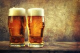 Two glasses of beer with foam on wooden table over grunge background