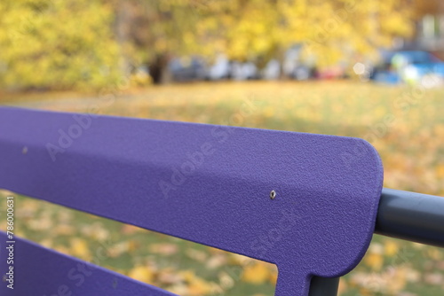  Lilac wooden bench in the autumn park 
