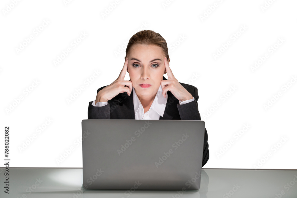 A woman in a business suit sitting at a desk with her laptop, looking stressed against a white background A woman in a business suit sitting at a desk with her laptop, looking stressed against a white background