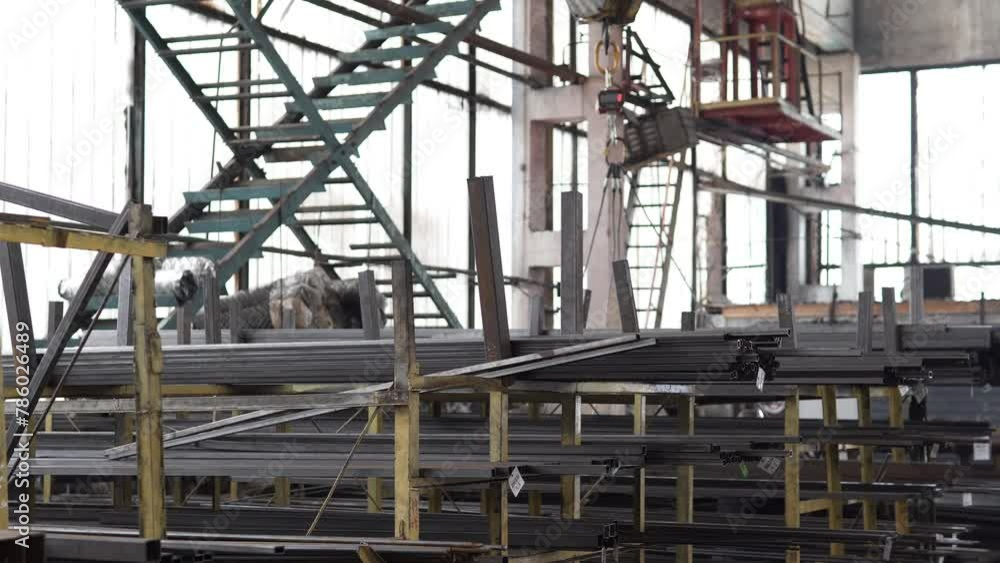 A worker moves large industrial metal parts using a remote control overhead rack crane. Heavy industry for manufacturing metal structures. A worker moves large industrial metal parts using a remote control overhead rack crane. Heavy industry for manufacturing metal structures.