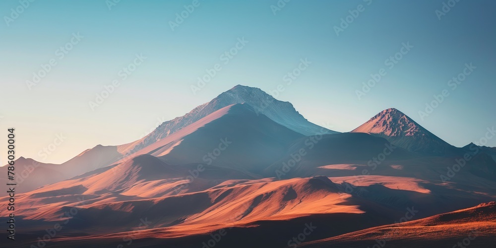 This stunning image captures the serene beauty of mountain peaks bathed in the warm glow of a setting sun