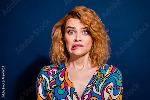 Portrait of worried nervous cute woman wear trendy clothes bite lips isolated on dark blue color background photo