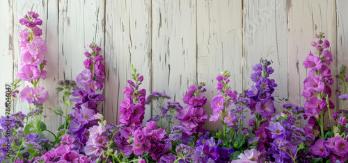 A row of purple flowers are in a vase on a wooden table