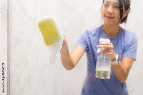 Woman clean the hard water stains and deposits in bathroom