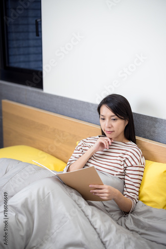Woman read on notebook on bed