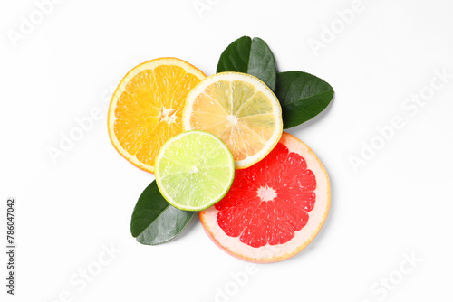 Slices of fresh ripe citrus fruits and green leaves on white background  flat lay