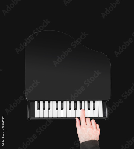top view of male musician hand playing small grand piano. isolated on black. music background