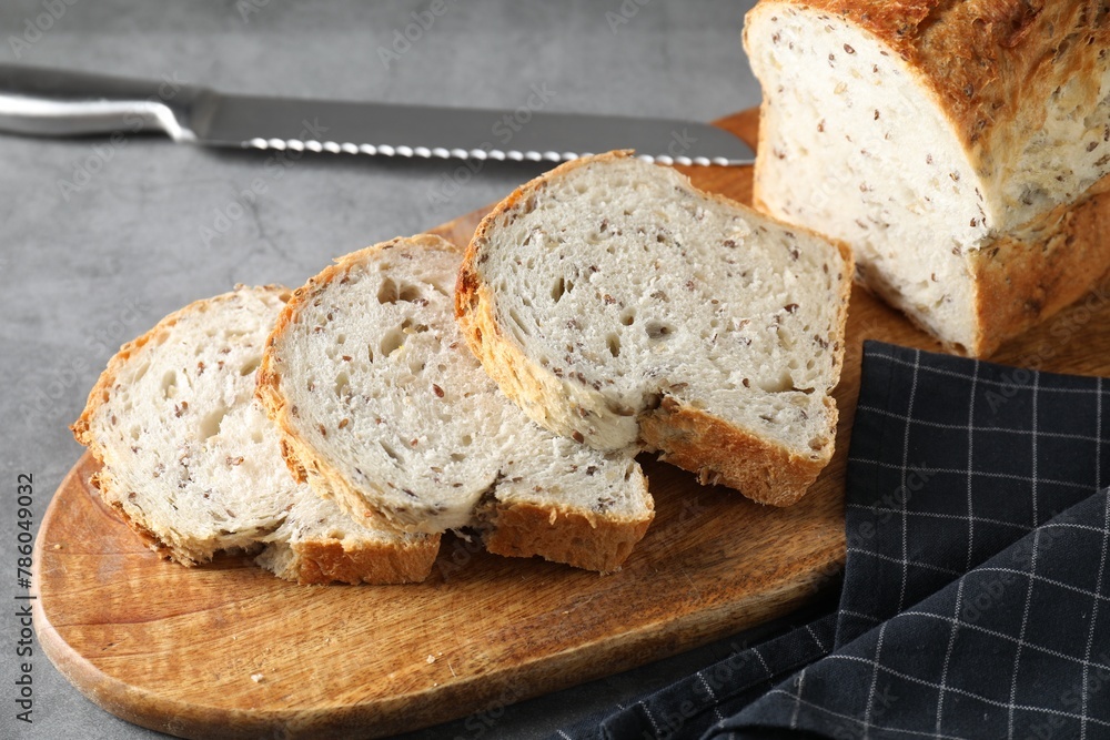 Freshly baked cut sourdough bread and knife on grey table, closeup Freshly baked cut sourdough bread and knife on grey table, closeup