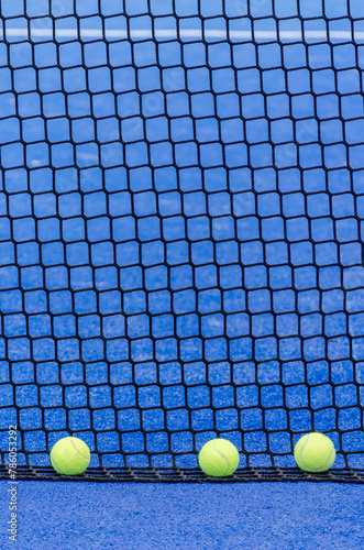 balls next to a paddle tennis court net, racket sports © Vic