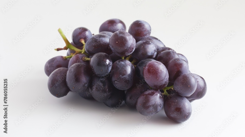 Fototapeta premium A bunch of seedless purple grapes on a white surface