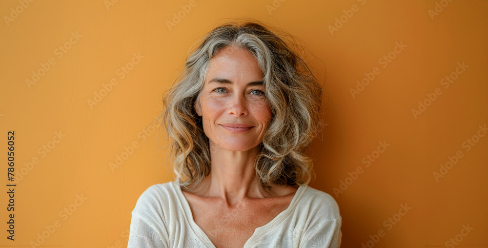A woman with gray hair is smiling at the camera A woman with gray hair is smiling at the camera