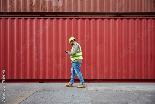 worker or engineer walking forward and working on tablet in containers warehouse storage © offsuperphoto