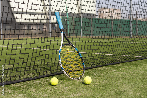 tennis racket with balls on green background.