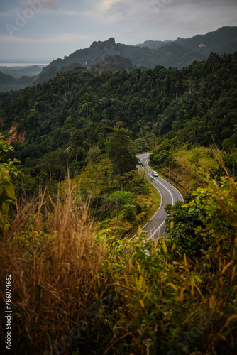 Winding curvy rural road leading through Perlis, Malaysia countryside.