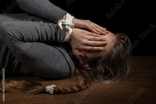 Tied girl on the floor. Stop abusing child violence, human trafficking, Human Rights Day concept photo