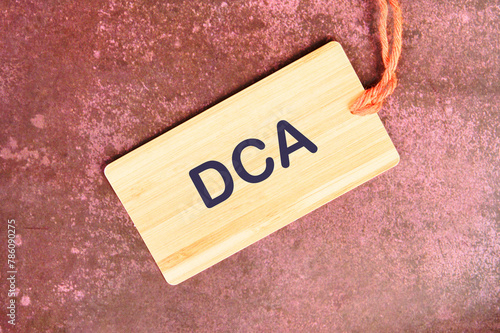 Business concept. Dollar cost averaging investment strategy. DCA on a card with a rope on an abstract background photo