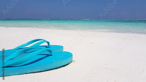 Closeup of flip-flops at a beach on a summer sunny day