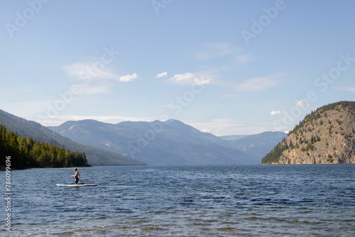 Paddle boarder on a lake with mountains in the background