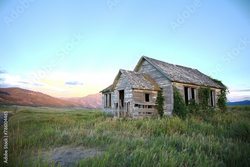 Old abandoned house in the middle of a meadow under a clrear sky