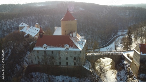 Drone shot over Veveri Castle with forest trees in Brno, Czechia and snowy ground