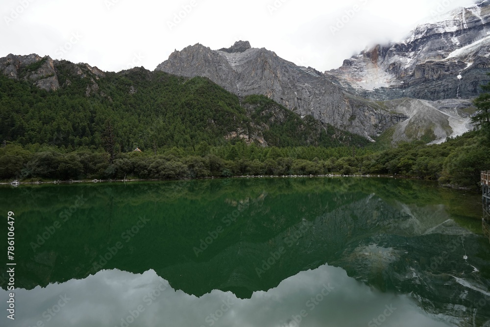 Lake and cloud-capped mountains in the Daocheng Yading National Park, Sichuan, China.