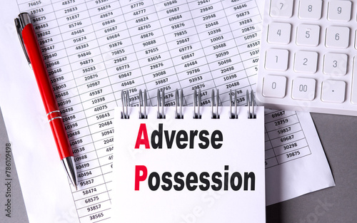 ADVERSE POSSESSION text on notebook with chart , pen and calculator photo