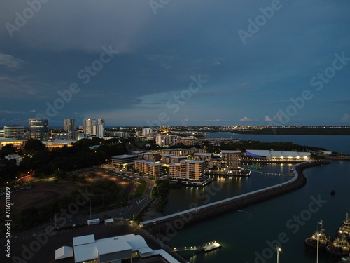 Aerial view of a seaside city with lots of buildings, skyscrapers and roads in the evening