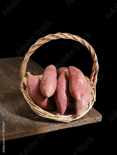 A basket of sweet potatoes on a wooden table