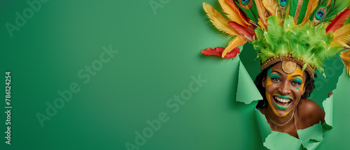 Excited woman in a carnival costume punches through a green paper background with glee and energy