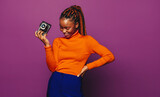 African woman photographing on vibrant purple background