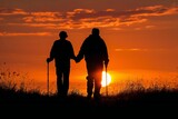 Silhouette of elderly man assisted by father during sunset walk