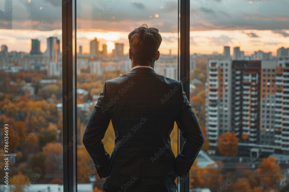 Man Standing in Front of Window, Looking at Cityscape Man Standing in Front of Window, Looking at Cityscape